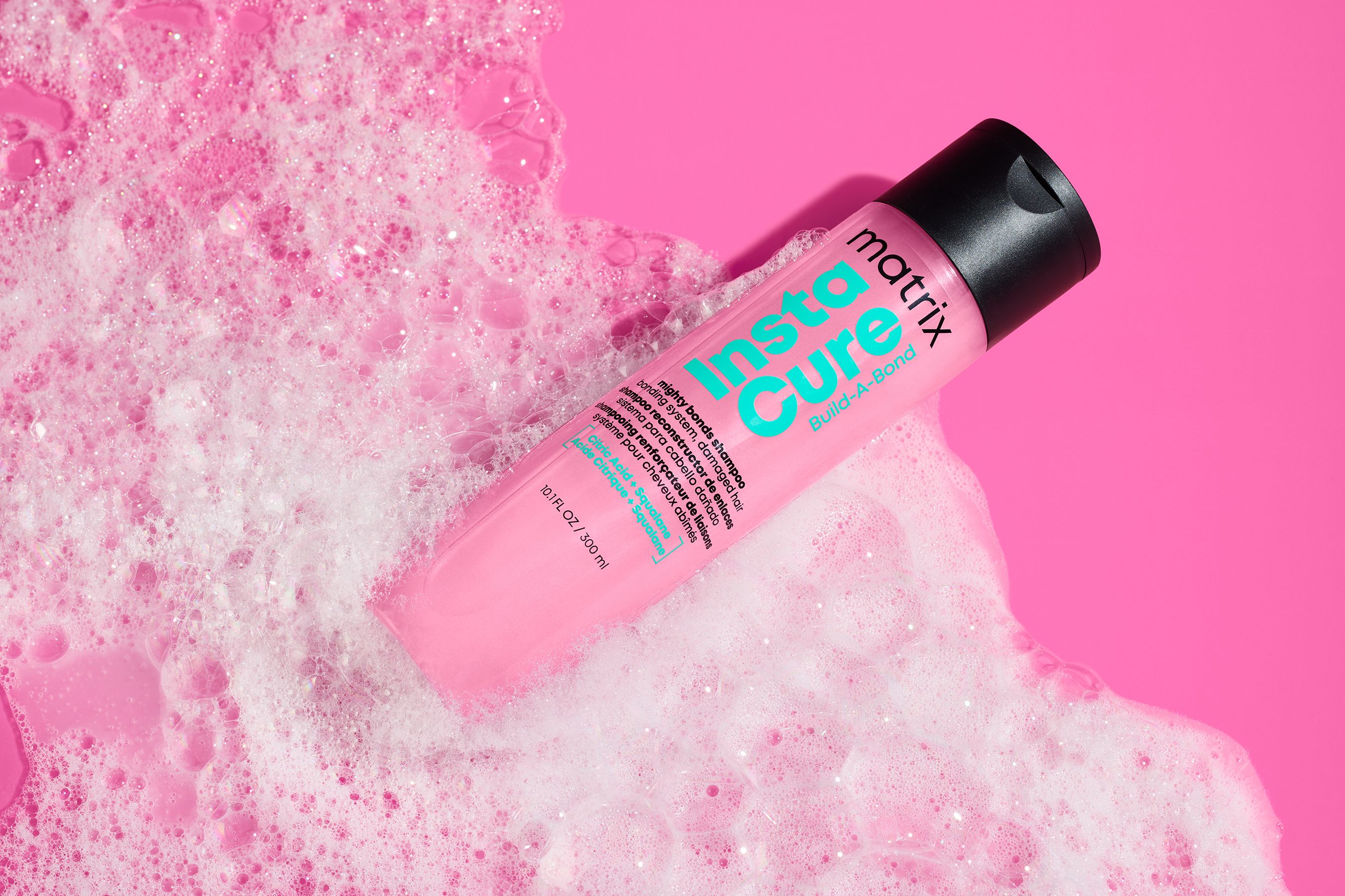 Matrix Insta-Cure Build-A-Bond on hot pink with foam. Active care positioning, with the typography doing real work.